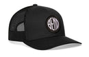 The Haka Hat Bend Trucker Hat is a black mesh snapback with a curved bill and a round patch featuring "BEND" in white letters—a classic Bend, Oregon hat from Haka Hat.