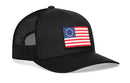 The Haka Hat Betsy Ross Flag Trucker Hat features black mesh, a 13-star flag patch, red and white stripes, and an adjustable snapback closure for a perfect USA-inspired fit.
