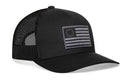 The Haka Hat Betsy Ross Flag Trucker Hat is a black mesh-back snapback featuring a monochrome embroidered USA flag patch with a circle of stars and gray stripes, inspired by the classic Betsy Ross design.