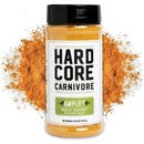 The Hardcore Carnivore BBQ Rub Sampler Set is displayed upright, with vibrant orange-red savory seasoning powder in the background—the ideal choice for BBQ flavor enthusiasts.