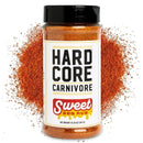 A Hardcore Carnivore BBQ Rub Sampler Set stands before a pile of reddish-brown seasoning, its label visible and rub scattered around—an ideal choice for enhancing any BBQ seasoning bundle.