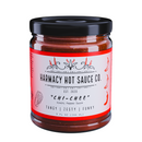 A 9oz glass jar of Harmacy Hot Sauce Co. Chi-Chee Kimchi Sauce with a red label featuring peppers, flames, and Tangy | Zesty | Funky highlights. A bold, fermented hot sauce experience from Harmacy Hot Sauce Co.