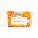 A 2-pack of In The Curious Kitchen Beer Cheese Kentucky Original Spread features creamy cheddar dip in 10 oz (284g) plastic containers with an orange and yellow label, offering classic nostalgic flavor in every bite.