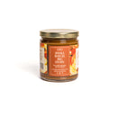 In the Curious Kitchen Bourbon Apple Butter by In The Curious Kitchen comes in a glass jar with a gold lid and red label featuring fruit art, website, and social icons—ideal for Southern entertaining or charcuterie boards. "SMALL BATCH. BIG STORY.