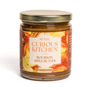 A 9 oz (255g) glass jar of In The Curious Kitchen Bourbon Apple Butter, featuring a gold lid and apple-themed label—ideal for Southern entertaining or charcuterie boards.
