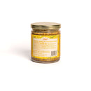 A glass jar of In The Curious Kitchen Bourbon Honey Mustard with a gold lid is shown with its yellow nutrition label facing forward. Handcrafted in Kentucky, this mustard is perfect for any charcuterie board and lists ingredients and nutrition facts.