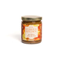 The In The Curious Kitchen Cheese Board Jam Gift Set Trio features Southern-inspired jams, perfect for any cheese or charcuterie board. The elegant jars with gold lids make an ideal gift, beautifully presented against a white background.