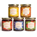The In The Curious Kitchen Southern Gourmet Spread Gift Set features five glass jars—bourbon honey mustard, apple butter, strawberry jalapeño jam, blueberry jam, and hot pepper jelly—ideal for charcuterie boards or gifting.