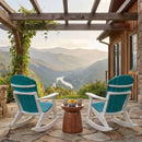 Two Kanyon Living Adirondack Rocking Chairs in Aruba Blue & White face a small table with cups and lemons on a stone patio under a pergola, overlooking a scenic mountain valley and winding river at sunrise.