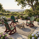 Three Kanyon Living Adirondack Rocking Chairs in Dark Green & Cherry Wood circle a small table on a patio with a rug, surrounded by flowers, potted plants, string lights, and scenic landscape views.