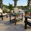 The Kanyon Living Poly Lumber Oval Coffee Table in Dark Green & Cherry Wood is set on a patio with books, a teapot, and a cup, surrounded by cushioned chairs, potted plants, and flowers beneath a pergola in a lush garden.