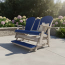 The Kanyon Living Poly Lumber 5′ Adirondack Glider Tall Version in blue and light grey adds comfort and style to any patio or garden, shown here surrounded by ferns and hydrangeas with a stone wall in the background.