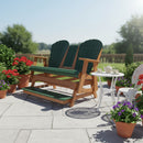 A Kanyon Living Poly Lumber 5′ Adirondack Glider Tall Version in dark green and cedar adds rustic charm to a sunny patio, paired with a small white tea table and colorful potted flowers for an inviting Amish-made setting.