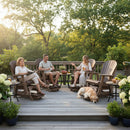 Three adults relax on Kanyon Living Poly Lumber Adirondack Glider Chair Tall Deluxe in Brazilian Walnut and Weathered Wood, chatting and enjoying snacks. A golden retriever rests nearby, with lush greenery and trees in the background.
