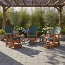 Three Kanyon Living Poly Lumber Adirondack Glider Chairs in tall dark green and cedar wood sit under a pergola on a stone patio, surrounded by potted plants. Small tables with mugs stand beside each eco-friendly chair from Kanyon Living.