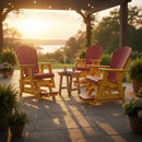 Four colorful Adirondack chairs, including the Kanyon Living Poly Lumber Adirondack Glider Chair Tall Red and Yellow, surround a small table with two mugs on a patio at sunset under string lights and a pergola, with potted plants and water view in the background.