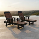 Two Kanyon Living Poly Lumber Chaise Lounges with Arms in Deluxe Antique Mahogany and Black sit by an infinity pool at sunset. Eco-friendly and stylish, they pair with a small table for the perfect outdoor relaxation setup.