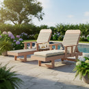 Two Kanyon Living Poly Lumber Chaise Lounges with Arms (Light Grey/Weathered Wood) sit poolside on a stone patio with lush greenery and hydrangeas. A small table holds two glasses and a carafe between the chairs.