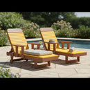 Two Kanyon Living Poly Lumber Chaise Lounges with Arms in Yellow and Cedar Wood sit by the pool on a stone patio. One chair has a sunhat, the other a rolled towel. Lush greenery creates a relaxing outdoor backdrop.
