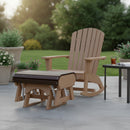 A Kanyon Living Poly Lumber Gliding Ottoman Deluxe in Brazilian Walnut and Weathered Wood sits with a brown Adirondack rocker by a black table of iced tea, surrounded by potted plants on a patio—perfect rustic outdoor relaxation.