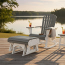 A Kanyon Living Adirondack rocking chair and a Kanyon Living Poly Lumber Gliding Ottoman Deluxe Driftwood Grey and White sit on a deck by a peaceful lake. A drink with ice rests on the arm, with a light throw draped—ideal outdoor furniture.