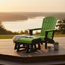 A Kanyon Living Poly Lumber Gliding Ottoman in lime green and black sits on a wooden deck by the lake at sunset, paired with outdoor furniture. A blanket, open book, eyeglasses, mug, and potted plant add charm to the relaxing scene.