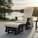A Kanyon Living Poly Lumber Gliding Ottoman in Seashell and Black sits beside a wooden Adirondack chair on a deck by a calm lake at sunset, with a light knit blanket draped over the chair’s armrest and trees in the background.