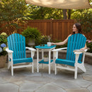 A woman sits on an Adirondack chair beside the Kanyon Living Poly Lumber Tall Oval Side Table in Aruba Blue & White, holding a mug in a garden with plants, flowers, and a wooden fence in the background.