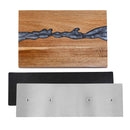 The DDR BBQ Supply Magnetic Knife Block Double-Sided Acacia Wood Knife Holder with Blue/Grey Resin features a rectangular acacia wood design highlighted by a striking blue/grey resin river. Displayed above a black rubber mat and a brushed metal plate with four holes, this elegant double-sided magnetic knife block provides practical and stylish storage for your kitchen essentials.