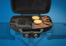 A Napoleon Cast Iron Reversible Griddle for TravelQ 285 Series (56080) by Napoleon Grills displays pancakes, bacon, and sausages sizzling on its flat surface, set against a blue background.