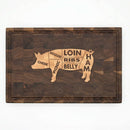 The Two Acre Woodworks Pig Cuts Cutting Board (18.5"x12"x2") features a labeled pig illustration—cheek, shoulder, picnic, loin, ribs, belly, ham—ideal for BBQ prep and identifying meat cuts.
