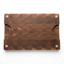 Introducing the Pig Cuts Cutting Board 18"x12"x2" from Two Acre Woodworks—a rectangular end grain board with a checkered grain pattern, rounded corners, convenient side handles, and four white non-slip pads underneath for stability. Ideal for BBQ prep, it features a center-engraved logo.
