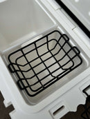 A close-up of the open Polar Bear 20 Hard Cooler by Polar Bear Coolers reveals its interior compartments, black metal basket insert, and hinge details engineered for superior ice retention.