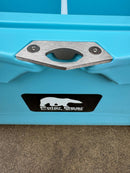 Close-up of the Polar Bear Coolers 45 Hard Cooler with a silver metal latch and black sticker featuring a white polar bear logo, shown on a concrete surface—engineered by Polar Bear Coolers for long-lasting ice retention.