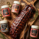 The Saltopia Ribs Bundle - Fall Off the Bone Flavors by SALTOPIA Infused Sea Salts features a glazed rack of ribs with four infused sea salt blends, tongs, and spices—perfect for creating unique BBQ rib flavor profiles.