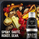 A tray of roasted tomatoes, eggplant, and peppers sits behind a black can of South Chicago Packing Wagyu Beef Tallow Cooking Spray. White text reads: Spray. Sauté. Roast. Sear with nonstick ease from South Chicago Packing.