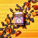 A tin of Spicewalla Minced Black Garlic by Spicewalla sits on an orange patterned cloth, surrounded by pieces and cloves of black garlic—showcasing this rich, umami-filled seasoning.