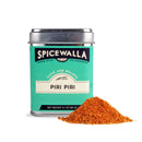 A metal tin of Spicewalla Piri Piri Seasoning features a teal label and silver lid, with a small pile of reddish-orange spice blend displayed in front. Net weight: 3.1 oz (88 g).