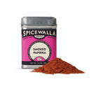 A tin of Spicewalla Smoked Paprika by Spicewalla rests beside a bright red heap of smoked paprika powder, ideal as a grilling or barbecue seasoning, displayed on a clean white background.