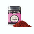 A metal tin of Spicewalla Sweet Spanish Paprika sits beside mild paprika powder, ideal for Spanish dishes, on a white background.