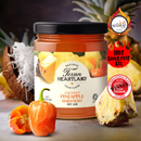A jar of Texan Heartland Coconut Pineapple Habanero Hot Jam is surrounded by fresh pineapple, coconut, and habanero peppers, with award badges and the HOT SAUCE FEST ATL logo displayed on the right.