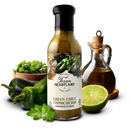A bottle of Texan Heartland Green Chile Chimichurri Marinade & Sauce sits on a white background, surrounded by fresh green peppers, cilantro, a halved lime, oil, and a wooden bowl of cilantro for vibrant Southwestern flavor.
