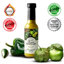A bottle of Texan Heartland Hill Country Verde Hot Sauce by Texan Heartland, made with roasted poblanos, is surrounded by fresh green peppers and a tomatillo. Award badges and a 2025 Fiery Food Challenge Winner label are shown around it.