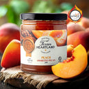 A jar of Texan Heartland Peach Amaretto Pecan Jam sits on a rustic wooden surface with fresh peach slices. The label shows peaches, pecans, and a Scovie award badge—ideal as a gourmet breakfast spread. Brand: Texan Heartland.