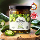 Texan Heartland Texan Candy Candied Jalapenos, award-winning at Scovie and International Flavor Awards, sits on a wooden surface with fresh jalapeños—bringing authentic Texas tradition and spicy flavor to your table.
