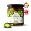 A jar of Texan Heartland Texan Candy Candied Jalapenos stands beside sliced jalapeños. Its white and green label features "Scovie Award" and "International Flavor Awards" badges, showcasing this spicy Texan Heartland topping.