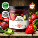 A jar of Texan Heartland Vanilla Strawberry Jalapeno Jam is displayed with fresh strawberries and jalapeños. Its label and award badges highlight the jam’s spicy, unique flavor and accolades for Texan Heartland.