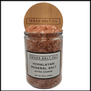 A clear glass jar with a round wooden lid etched with "Texas Salt Co" holds Texas Salt Co. Himalayan Pink Extra Coarse Salt, Net Wt 15oz (425g). The label states "Texas Salt Co. Himalayan Mineral Salt, Extra Coarse.