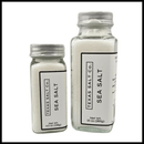 Two clear glass jars with silver lids hold Texas Salt Co. Pure Pacific Table Salt. Each jar’s white label shows the brand; sizes are 4.5 oz (128g) and 10 oz (283g)—ideal for everyday seasoning and cooking.