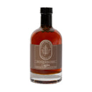 A clear glass bottle with a black cap contains amber Coffee Maple Syrup from Under The Bark Syrup Co, featuring a brown label with a maple leaf design and the text "Under The Bark Syrup Co Coffee Maple Syrup.